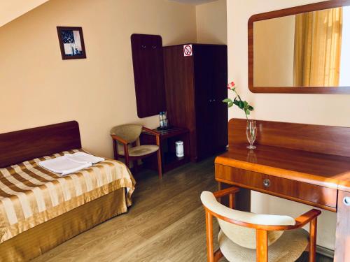 a bedroom with a bed and a desk and a mirror at Zajazd Emida 