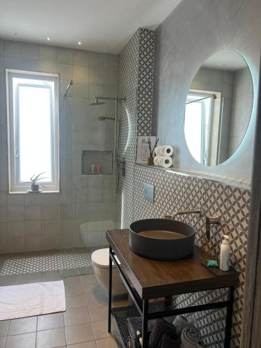 a bathroom with a sink and a toilet and a mirror at Cute little Penthouse in the Heart of Sliema in Sliema