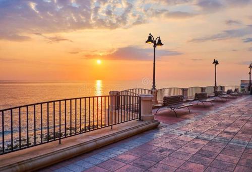 a row of benches on a pier near the ocean at Cute little Penthouse in the Heart of Sliema in Sliema
