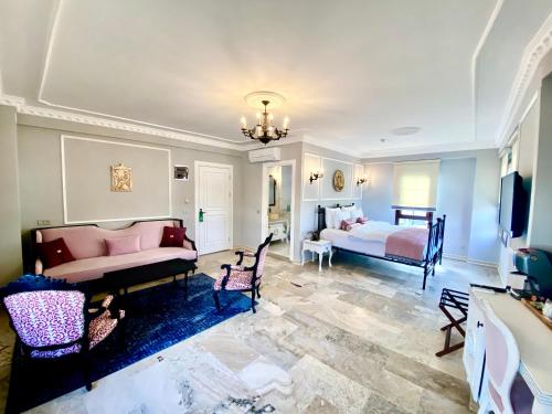 a living room with two beds and a tv at Villa Ephesus Hotel in Kusadası