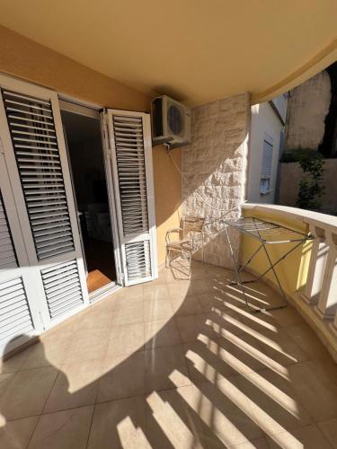 a balcony with a table and chairs in a house at Seashell Hideaway Apartment in Pržno