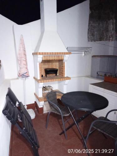 a dining room with a table and a fireplace at Moradia Rocleo Tavira House in Tavira