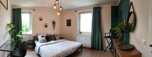 a bedroom with a bed and a table and windows at Ruhige Wohnung zwischen Harz & Göttingen - 4 Personen in Wulften