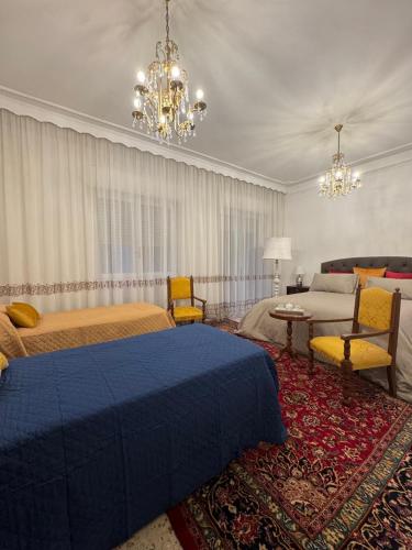 a bedroom with two beds and a chandelier at Prestige Rooms in Reggio Calabria