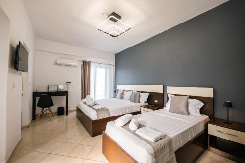 a hotel room with two beds and a desk at Elio's Rooms in Ksamil