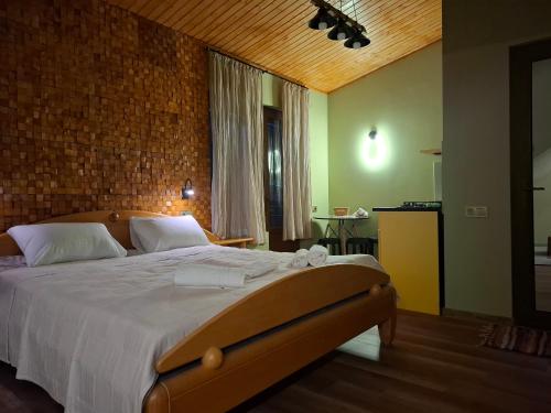 a bedroom with a large bed and a brick wall at Borjomi Nest 2 in Borjomi