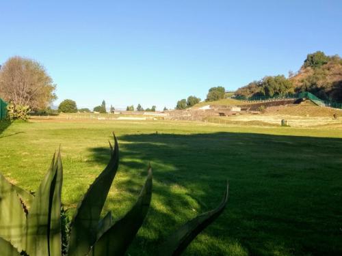 a large field of green grass with a large hill in the background at El rinconcito in Cholula