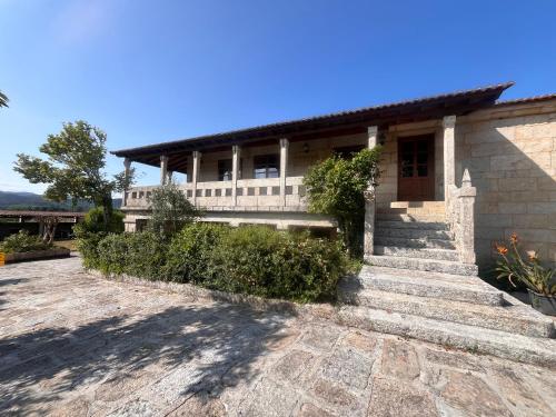 a house with stairs leading to the front of it at Pazo Carballo Hotel in Sampaio