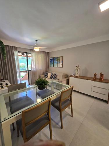 a living room with a glass table and chairs at Genipabu Summer House Guarajuba in Guarajuba