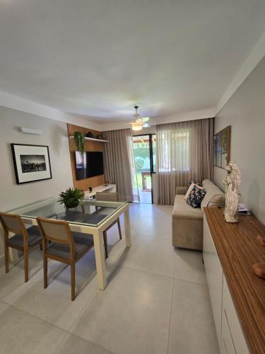 a living room with a table and a couch at Genipabu Summer House Guarajuba in Guarajuba