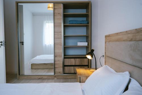 a bedroom with a mirror next to a bed at Batumi Apartment with Cozy Yard in Batumi