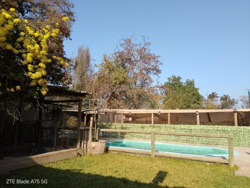 a swimming pool in a yard with a fence at Casa Niwa koi Entre Peces en Paine in Paine