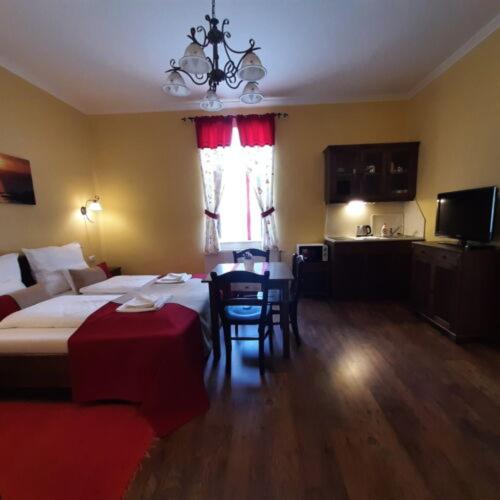 a hotel room with a bed and a table and chairs at Thermália Vendégházak - Tulipán Apartman in Kaba