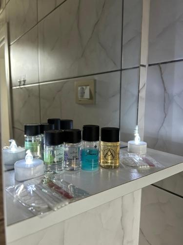 a shelf with a bunch of perfume bottles on it at Marias Apartments in Negotino