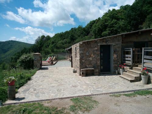 a stone building with a bench and a door at La Ferme Du Maquis in Antisanti