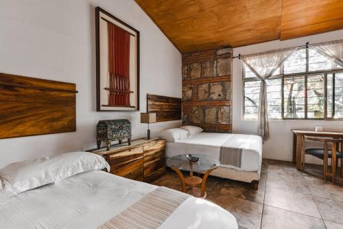 une chambre avec deux lits et une table et une fenêtre dans l'établissement 2 bedrooms Former Tannery Jalatlaco Neighborhood, à Oaxaca
