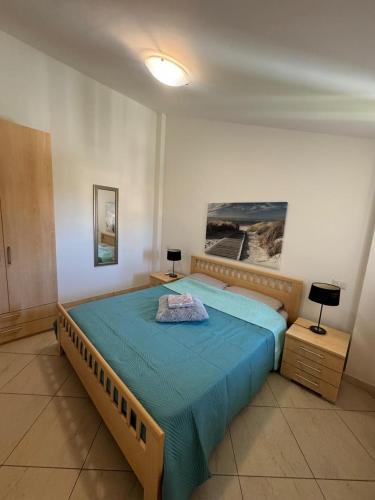 a bedroom with a large bed with a blue blanket at Pizzo Sabbia di Marinella in Pizzo