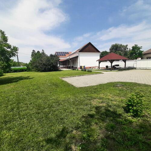 a large yard with a house and a pavilion at Thermália Vendégházak - Tulipán Apartman in Kaba