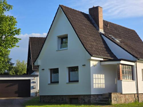 a white house with a brown roof at Ferienhaus am Großensee und Erholung vor den Toren Hamburgs in Großensee