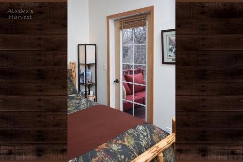 a bedroom with a bed and a red chair at Alaska's Harvest Bed and Breakfast and Luxury Log Cabin in Palmer