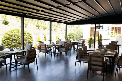 a restaurant with tables and chairs and windows at Ayan Palace Hotel in Tovuz