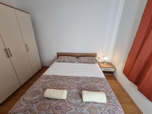 a small bedroom with a bed and two pillows at Villa Panorama in Pridraga
