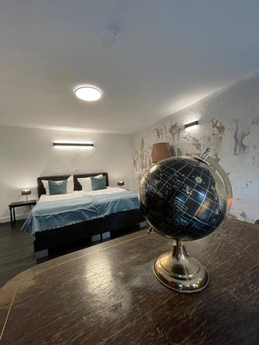 a room with a bed and a globe on a table at Bahnhofsoase - Wellness & Spa am Krufter Bahnhof in Kruft