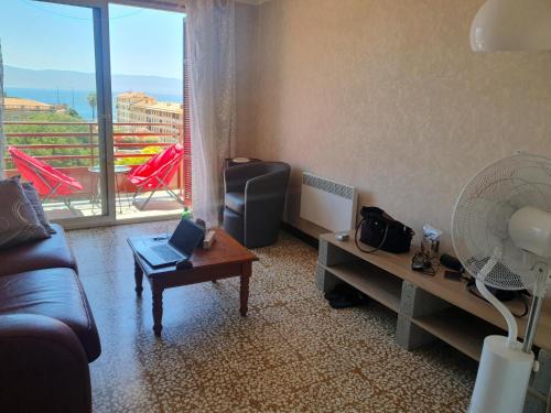 un salon avec un canapé et une table avec un ordinateur portable dans l'établissement L Essentiel, à Ajaccio