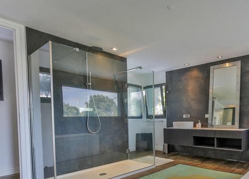 une salle de bain avec une douche en verre et un lavabo dans l'établissement maison traditionnelle avec belle vue, à Seignosse