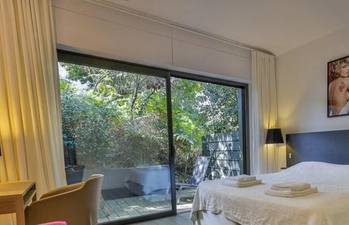 une chambre avec un lit et une grande fenêtre dans l'établissement maison traditionnelle avec belle vue, à Seignosse