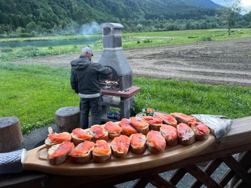 a man is cooking food on a grill at Haus am See in Mühldorf