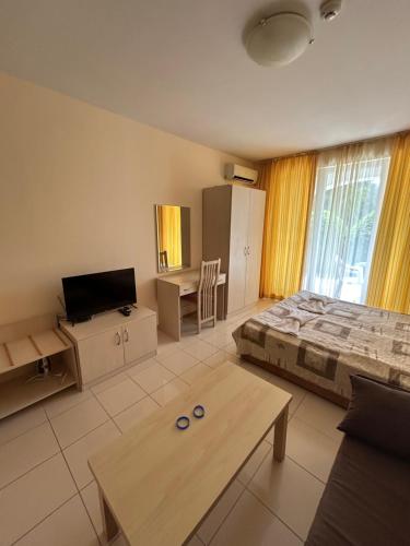 a bedroom with a bed and a table and a tv at Harmony Hills Tomovi Apartment C12 in Rogachevo