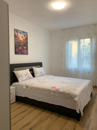a bedroom with a bed and a painting on the wall at Utjeha house Ana in Utjeha