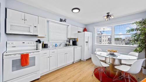 a kitchen with white appliances and a table with chairs at 2BR Beach Escape - Walk to Boardwalk - Parking in Ocean City
