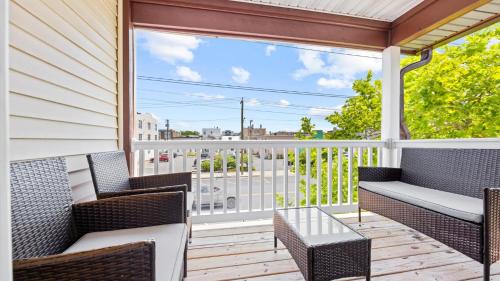 a balcony with wicker chairs and a view of a city at 2BR Beach Escape - Walk to Boardwalk - Parking in Ocean City