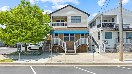 a house with stairs in front of a street at 2BR Beach Escape - Walk to Boardwalk - Parking in Ocean City