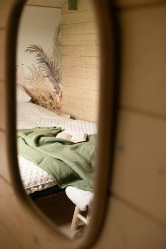 a mirror reflection of a bed in a bedroom at Dzika Warmia- domek bez sąsiadów na Warmii z balią i kominkiem in Glebisko