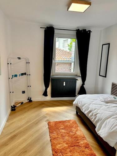 a bedroom with a bed and a window and a rug at Infinity-Flat Würselen City in Würselen
