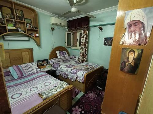 a room with two beds and a portrait of a man at فلورس لوج 