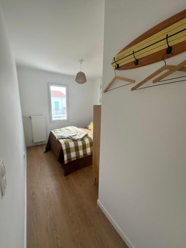 une chambre avec un lit dans une pièce blanche dans l'établissement Maison Stella, à Saint-Georges-dʼOléron