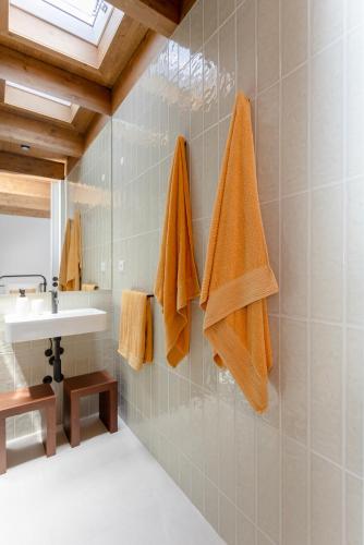 a bathroom with a sink and towels on the wall at Casa do Cipreste em Amarante in Gatão