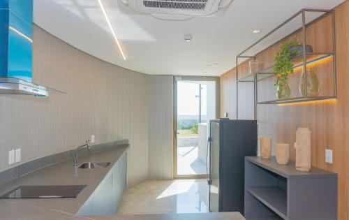 a kitchen with a sink and a refrigerator at Apartamento Vista Mar - Cais 1806 in Recife