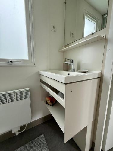 a white bathroom with a sink and a mirror at wallerseehomes 110 in Baierham