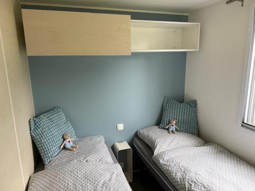 two beds in a small room with dolls sitting on them at wallerseehomes 110 in Baierham