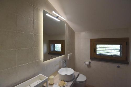 a bathroom with a sink and a mirror at Residence Il Cardellino in San Vincenzo