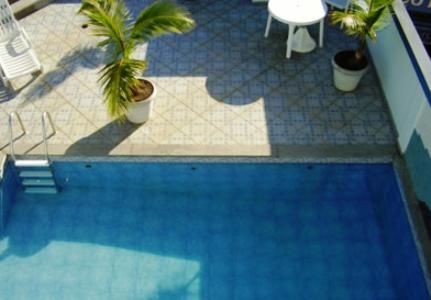 - une vue sur la piscine bleue et ses plantes dans l'établissement Crystal Apart Hotel, à Macaé