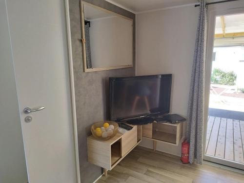 un salon avec une télévision à écran plat sur un meuble dans l'établissement Mobil-home 