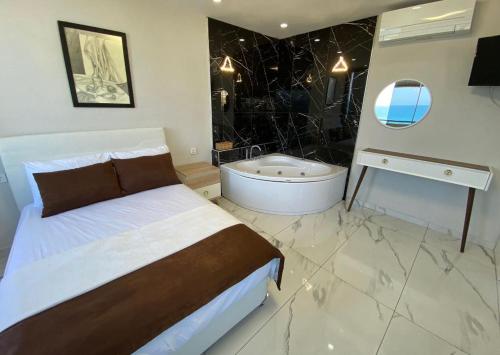 a bedroom with a bed and a bath tub at Beyaz motel in Erdemli