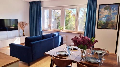 a dining room with a table and blue chairs at Rumia Cichy Zaułek 2 in Rumia