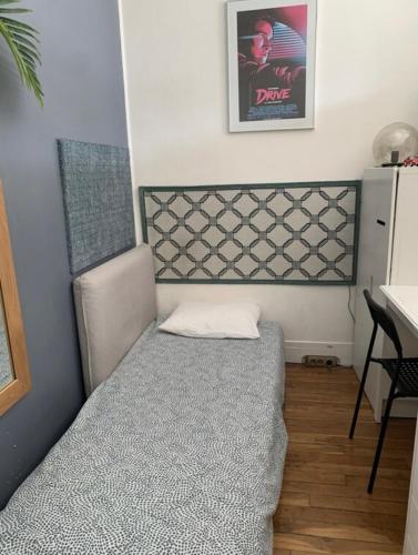 une petite chambre avec un lit et un bureau dans l'établissement Appartement typiquement parisien, à Paris